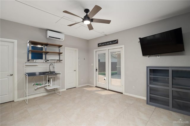 interior space with a wall mounted AC, access to exterior, french doors, and ceiling fan