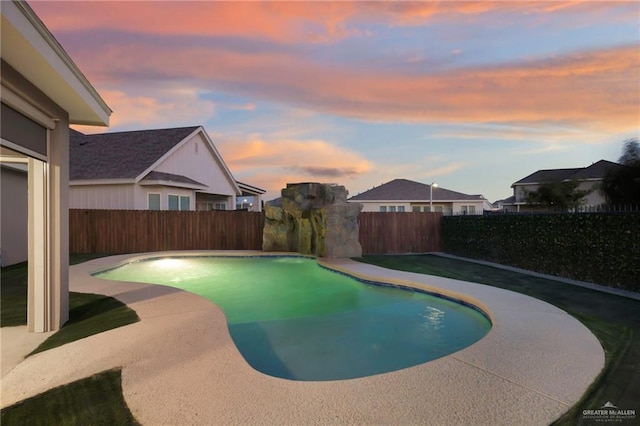 pool at dusk with a patio area