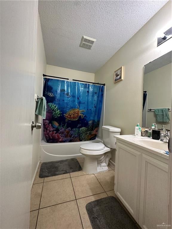 9205 N 31st St, Mcallen, TX 78504 - full bathroom featuring tile patterned floors, vanity, a textured ceiling, shower / bath combo with shower curtain, and toilet