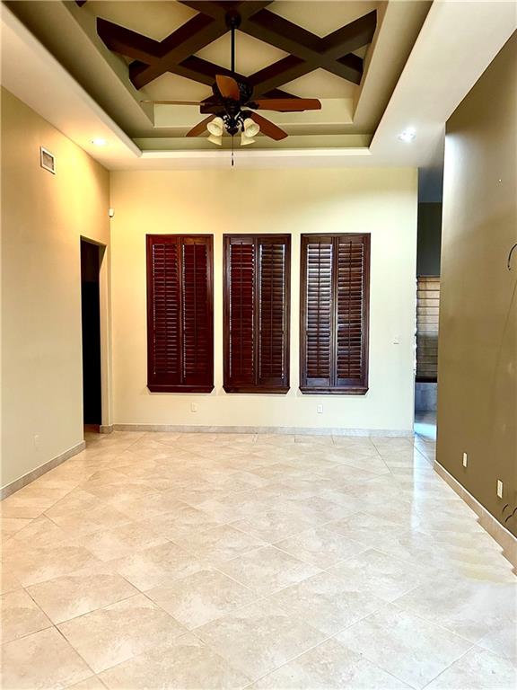 unfurnished room featuring ceiling fan, a raised ceiling, a high ceiling, and coffered ceiling