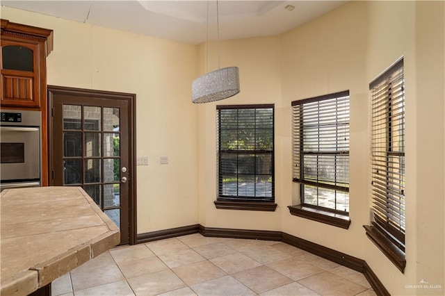 interior space featuring a towering ceiling and light tile patterned flooring