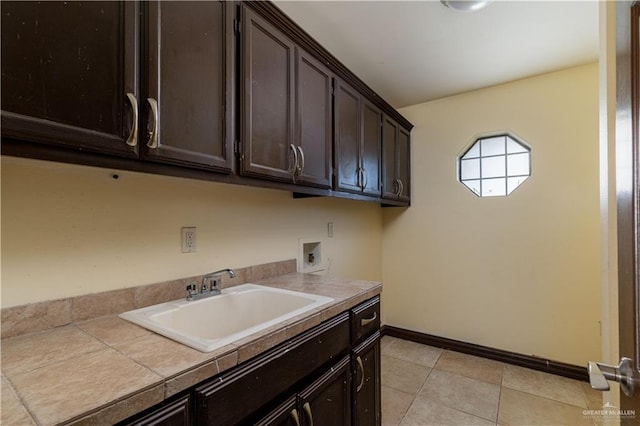 laundry room featuring cabinets, light tile patterned floors, sink, and hookup for a washing machine