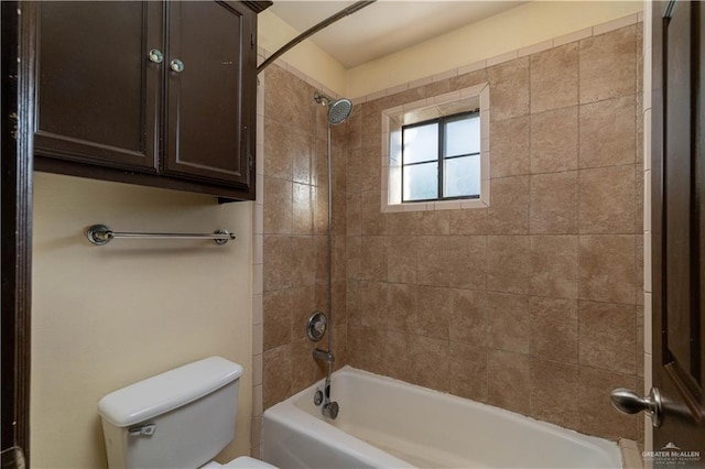 bathroom featuring tiled shower / bath combo and toilet