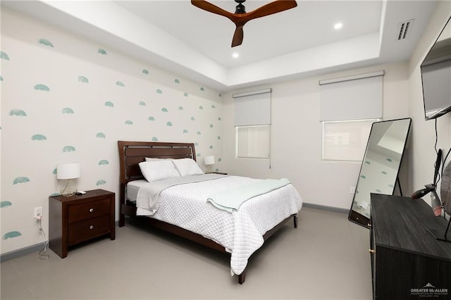 bedroom featuring a raised ceiling and ceiling fan