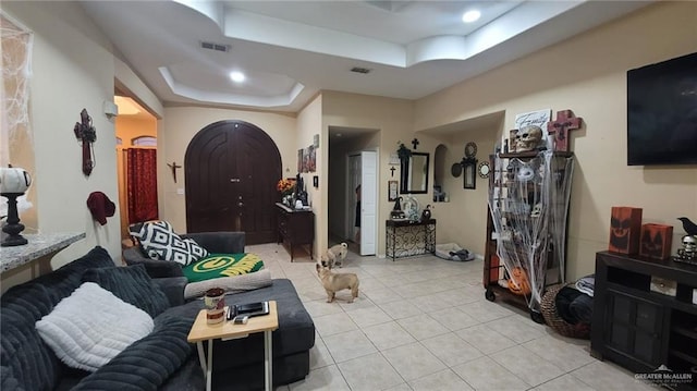 living room featuring light tile patterned floors and a tray ceiling