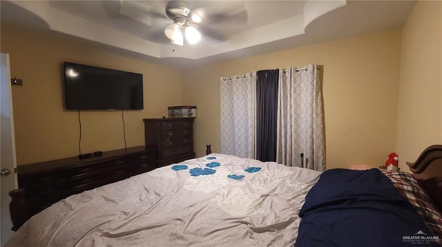 bedroom with a tray ceiling and ceiling fan