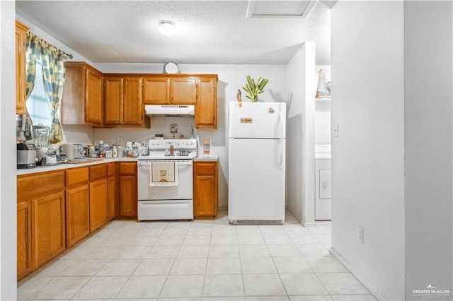 kitchen featuring a textured ceiling, light tile patterned flooring, white appliances, and washer / dryer