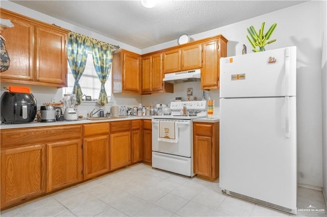 kitchen featuring sink, white appliances, and a textured ceiling