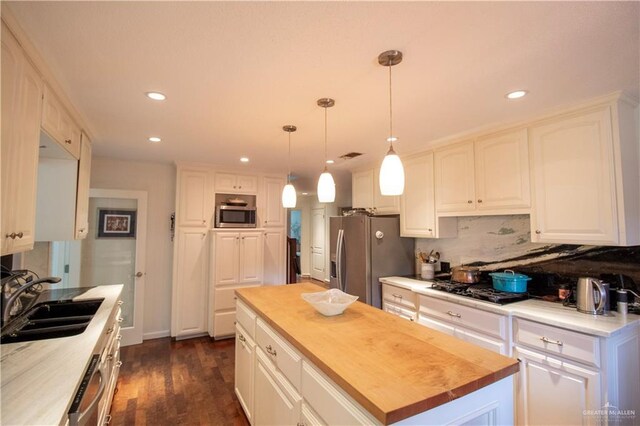 513 S Cynthia St, Mcallen, TX 78501 - kitchen featuring stainless steel appliances, white cabinets, decorative backsplash, recessed lighting, and butcher block counters