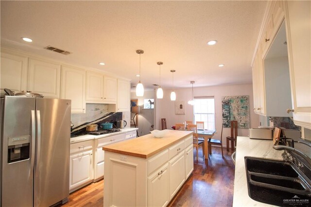 513 S Cynthia St, Mcallen, TX 78501 - kitchen with stainless steel fridge, butcher block countertops, recessed lighting, wood finished floors, and a center island
