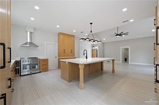600 Bluebird Ave, Mcallen, TX 78504 - kitchen featuring range with two ovens, wall chimney exhaust hood, light countertops, modern cabinets, and a breakfast bar area