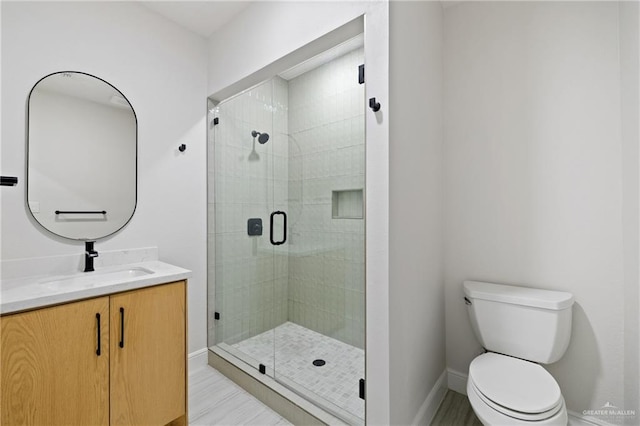 600 Bluebird Ave, Mcallen, TX 78504 - full bathroom featuring vanity, a stall shower, toilet, and baseboards