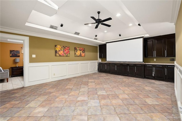 home theater room with crown molding, ceiling fan, and a tray ceiling