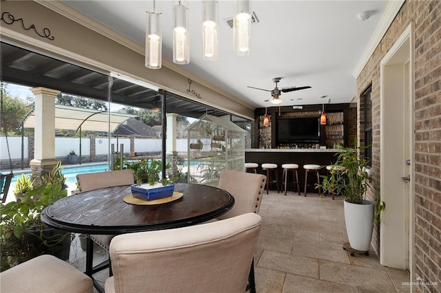 view of patio featuring a fenced in pool, exterior bar, ceiling fan, and a water view