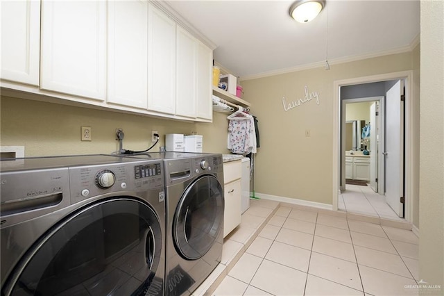 laundry area featuring cabinets, ornamental molding, washer and dryer, and light tile patterned flooring