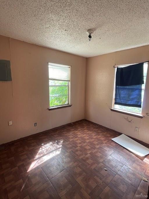 unfurnished room with a textured ceiling and electric panel