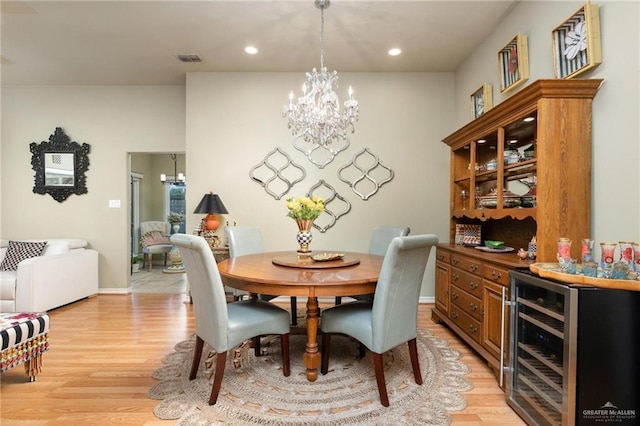 dining area with visible vents, wine cooler, light wood-type flooring, recessed lighting, and a notable chandelier