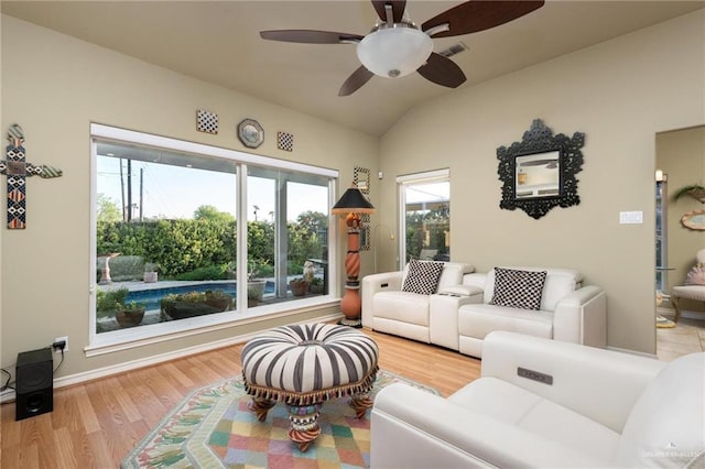 living area featuring lofted ceiling, wood finished floors, visible vents, and ceiling fan