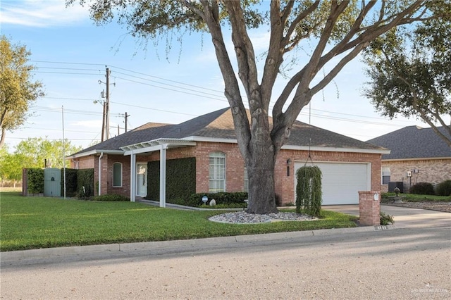 ranch-style home with a front yard, roof with shingles, an attached garage, concrete driveway, and brick siding