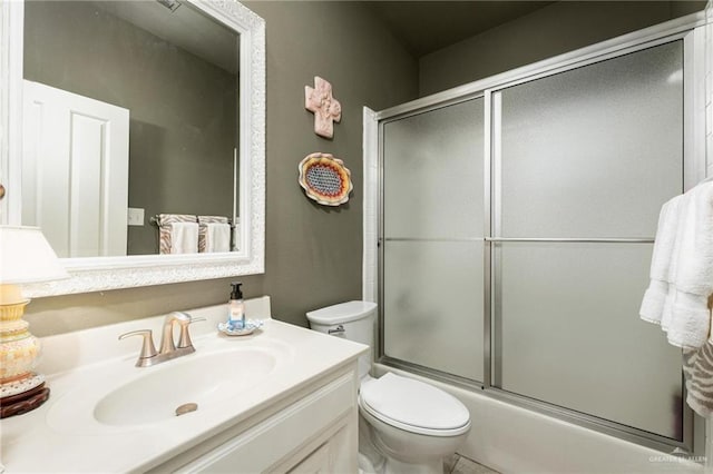 full bathroom featuring enclosed tub / shower combo, toilet, and vanity