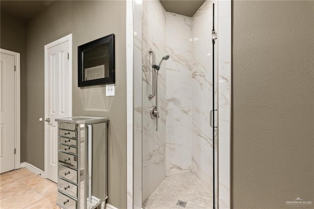 bathroom featuring a marble finish shower and baseboards