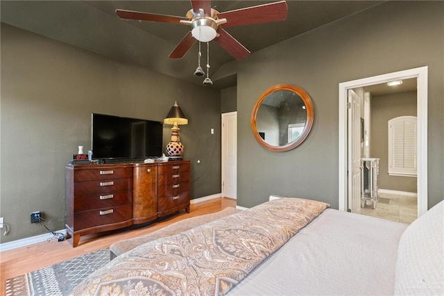 bedroom featuring light wood finished floors, a ceiling fan, and baseboards