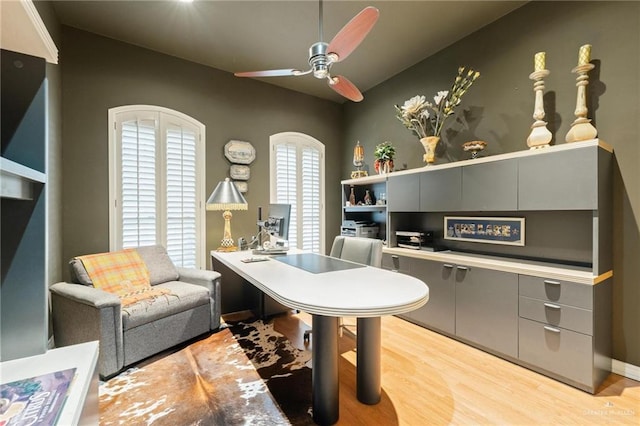 office with light wood-style floors and a ceiling fan