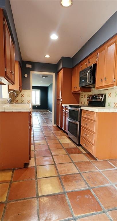 kitchen featuring decorative backsplash, sink, and appliances with stainless steel finishes