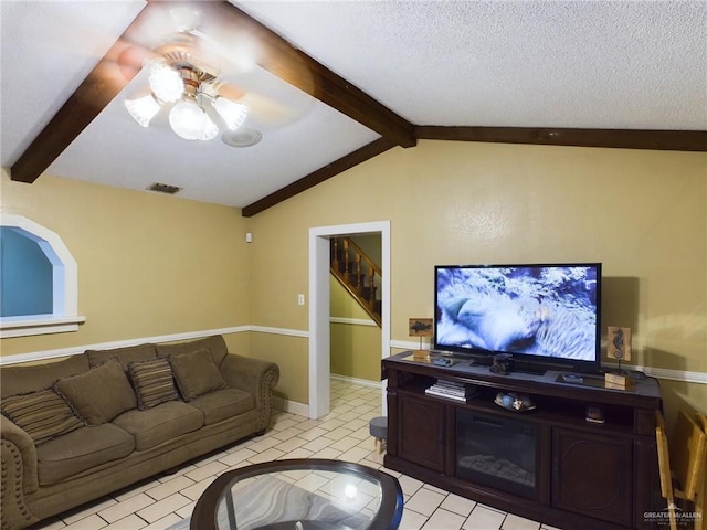 living room with stairway, visible vents, a textured ceiling, and lofted ceiling with beams