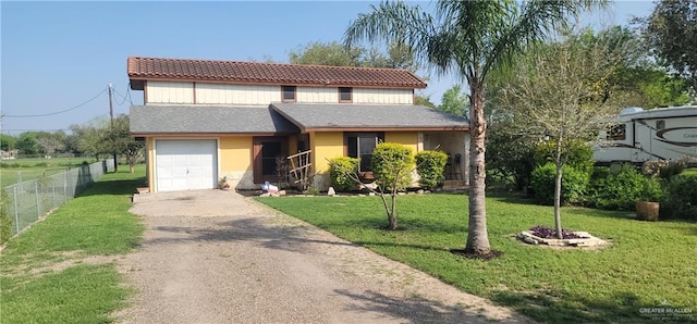 view of front of home with a garage, driveway, a front lawn, and fence