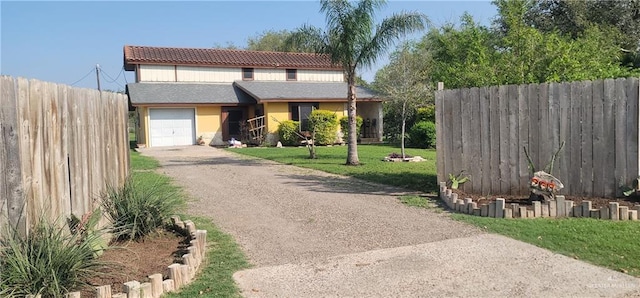 view of front facade with driveway, a front yard, fence, and a tile roof