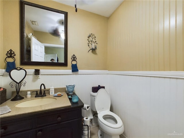 half bath featuring toilet, visible vents, and vanity