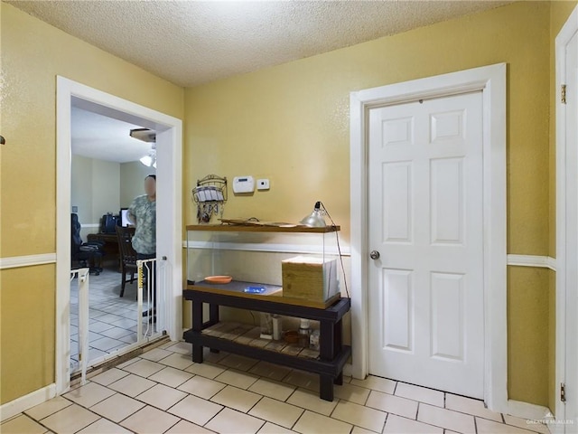 entryway with light tile patterned floors and a textured ceiling