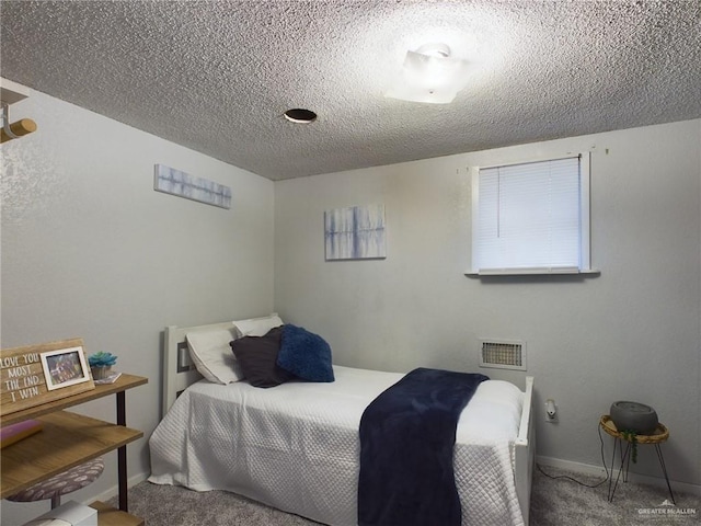 carpeted bedroom with visible vents, a textured ceiling, and baseboards