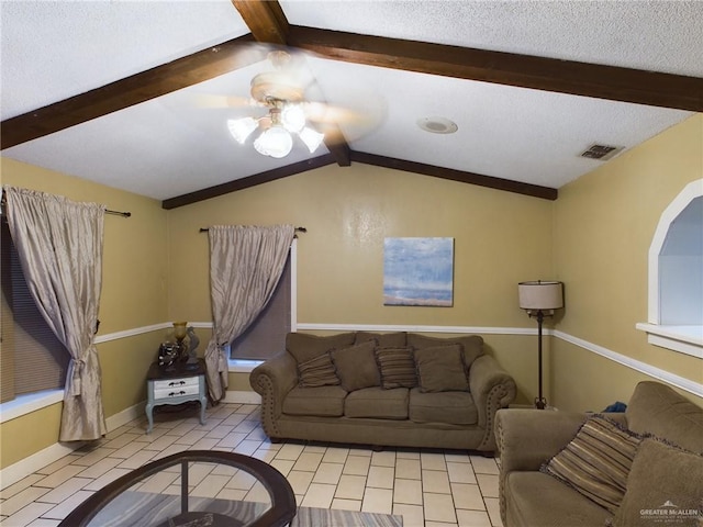 living room featuring baseboards, visible vents, ceiling fan, vaulted ceiling with beams, and a textured ceiling