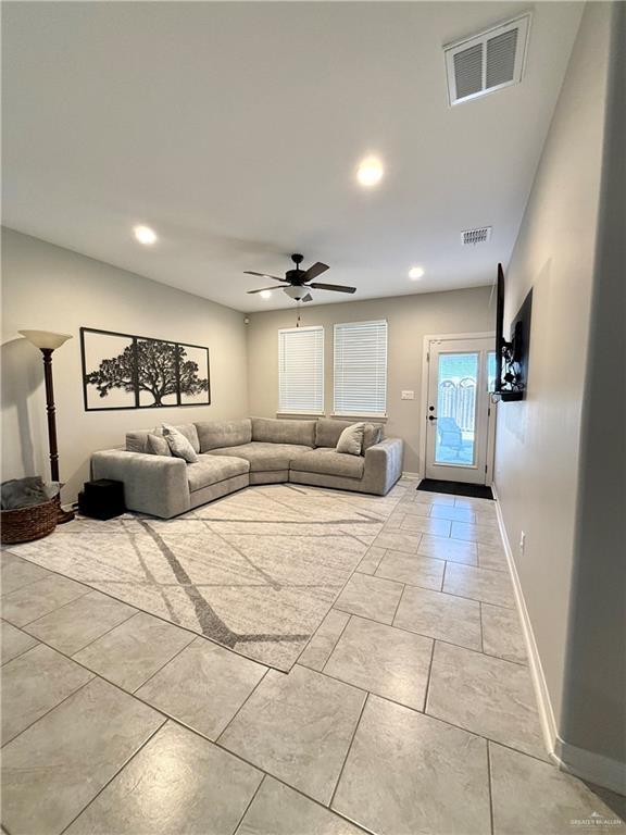 unfurnished living room featuring ceiling fan, baseboards, visible vents, and recessed lighting