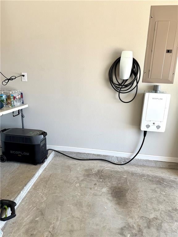 garage featuring electric panel and baseboards