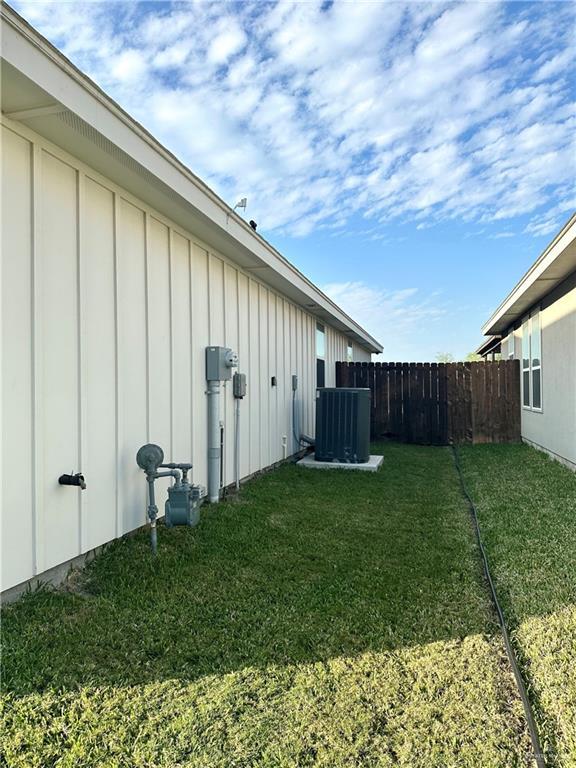 view of yard featuring fence and central air condition unit