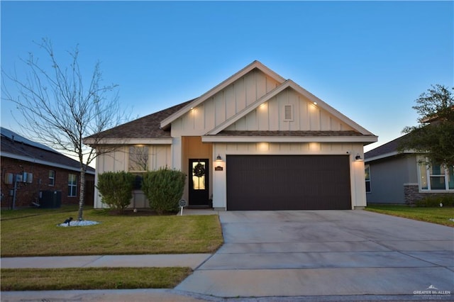 view of front of house featuring central air condition unit, a garage, driveway, a front lawn, and board and batten siding