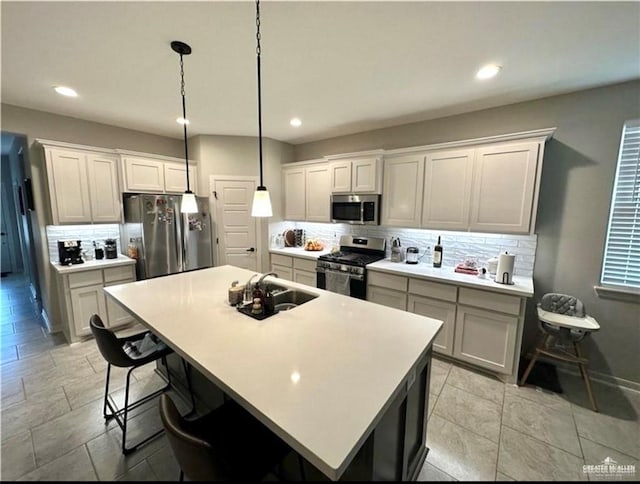 kitchen featuring a sink, a kitchen island, light countertops, appliances with stainless steel finishes, and decorative backsplash