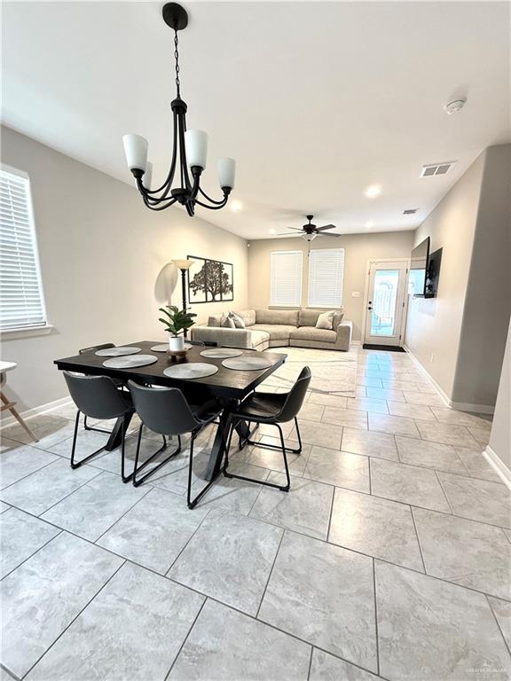 dining space featuring visible vents, baseboards, and ceiling fan with notable chandelier