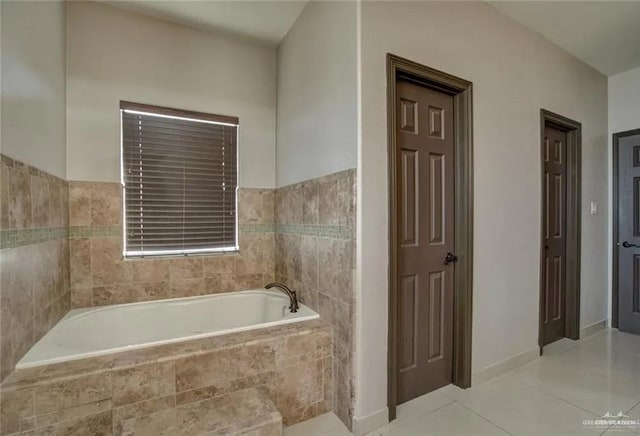 bathroom featuring tile patterned flooring and a relaxing tiled tub