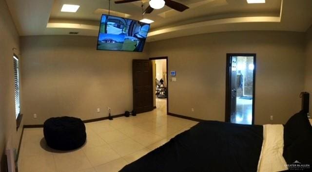 bedroom with ceiling fan and a tray ceiling