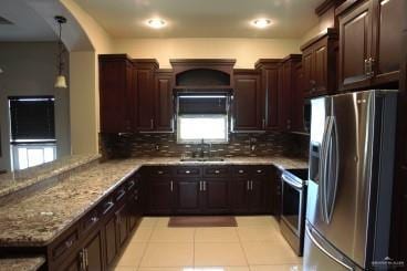 kitchen featuring hanging light fixtures, a wealth of natural light, sink, and stainless steel appliances