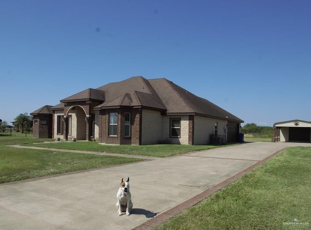 view of front of home featuring a front yard, an outdoor structure, central AC, and a garage