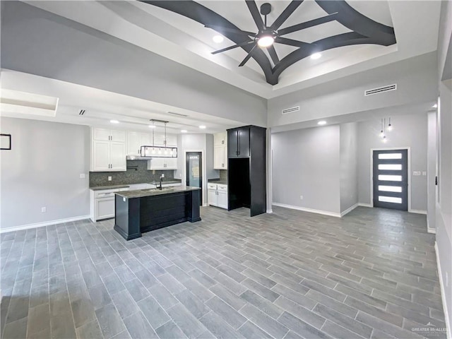 1271 Stirrup Cir, San Benito, TX 78586 - kitchen featuring a raised ceiling, open floor plan, baseboards, and recessed lighting