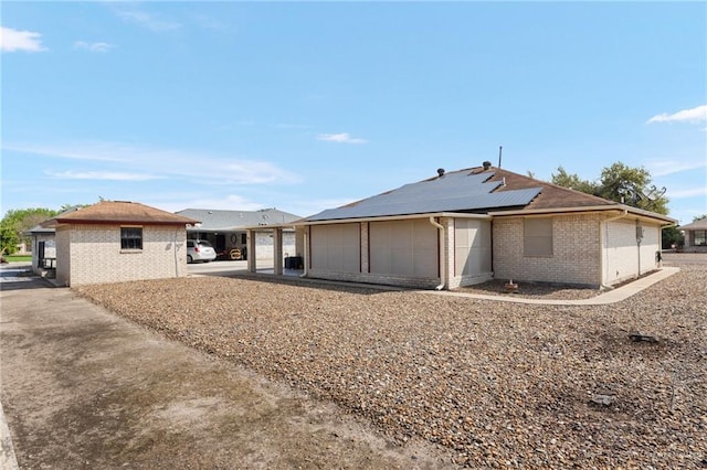 rear view of house featuring solar panels and a garage