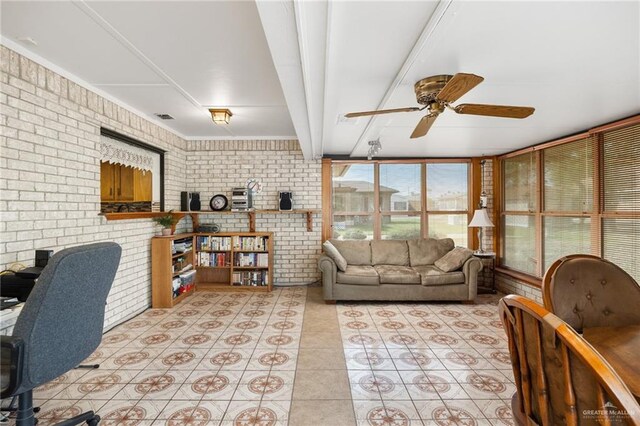 living room with beamed ceiling, ceiling fan, light tile patterned floors, and brick wall