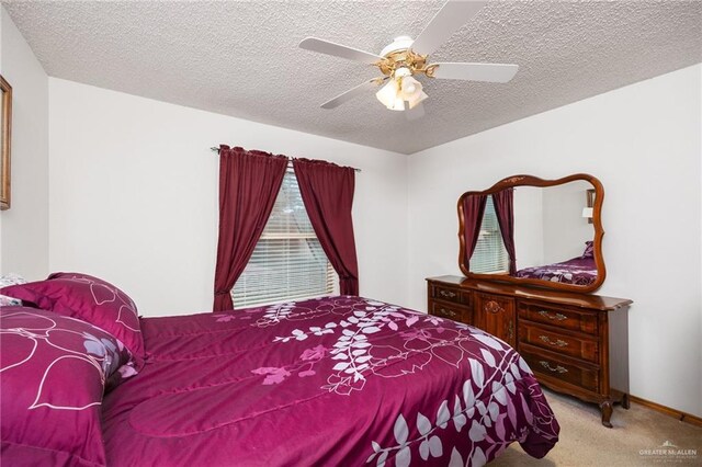 bedroom with a textured ceiling, light colored carpet, and ceiling fan