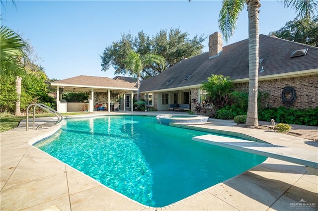 view of swimming pool featuring an in ground hot tub, a patio, and a diving board